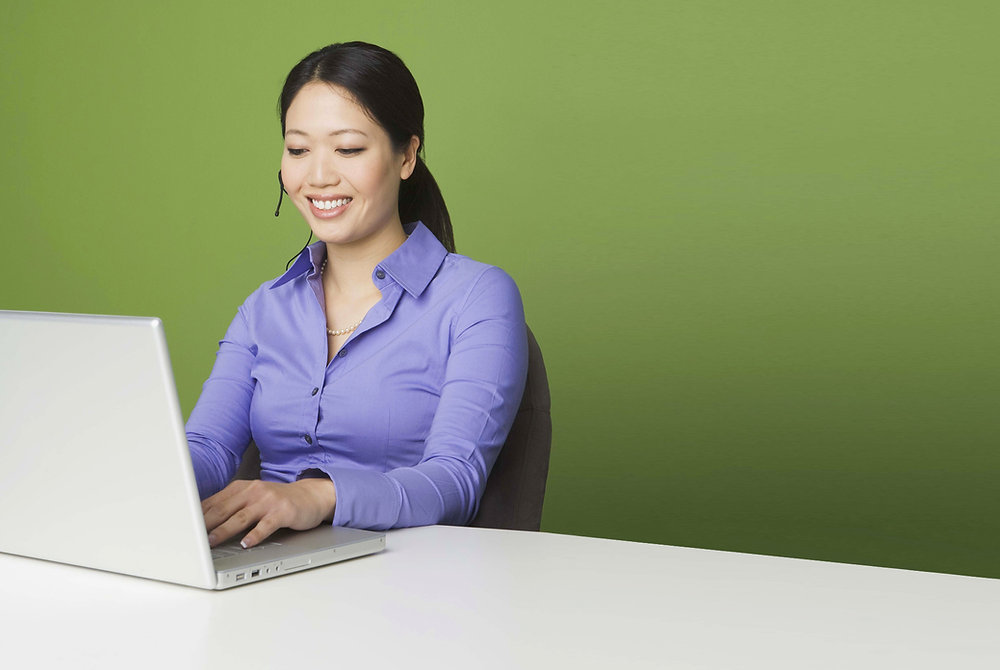 Woman using a laptop at a desk.
