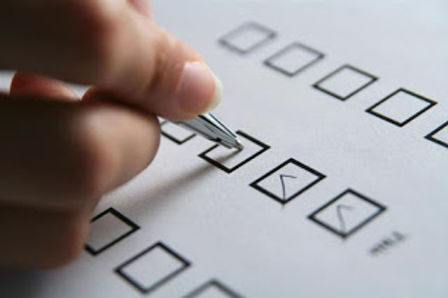 Hand marking a checklist.