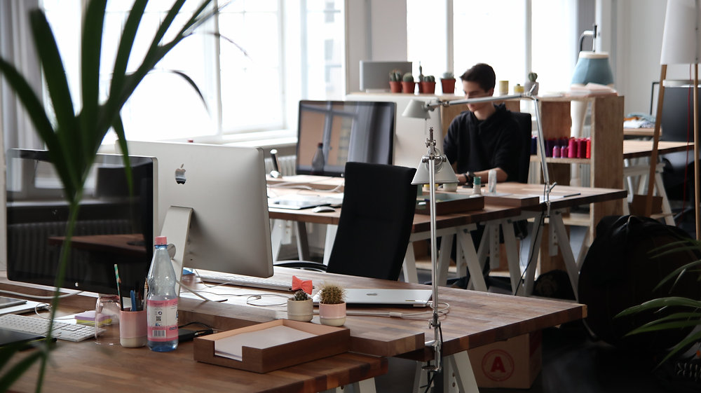 Person working at a computer in an open-plan office.