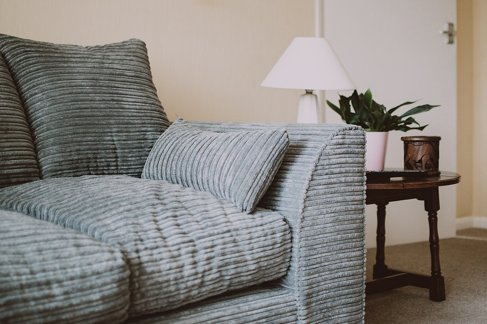 Modern living room with gray sofa and patterned cushions.